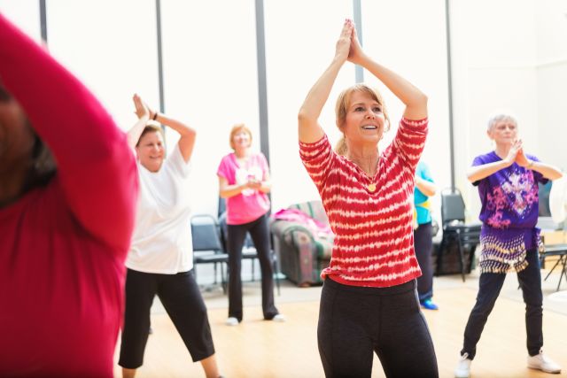 A middle-aged white woman dances in a dance therapy class.