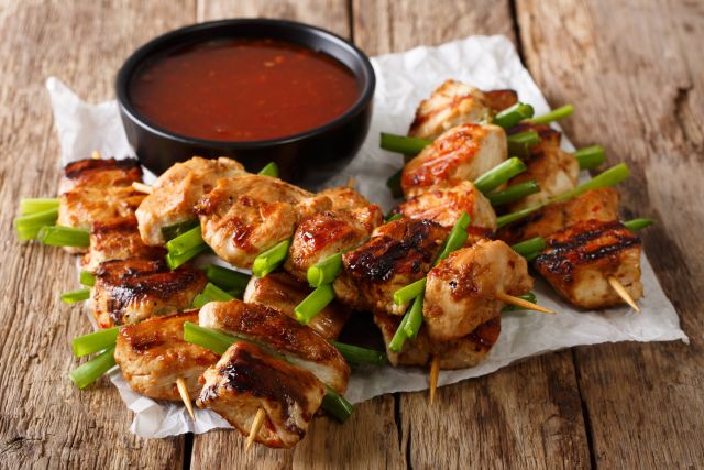 Chicken yakitori served on a paper napkin with dipping sauce