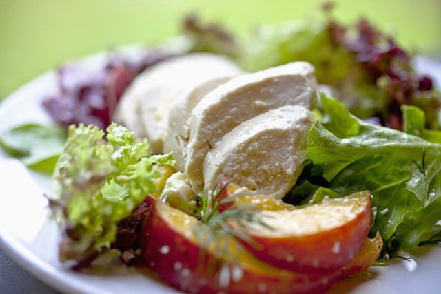 a poached chicken breast served over greens