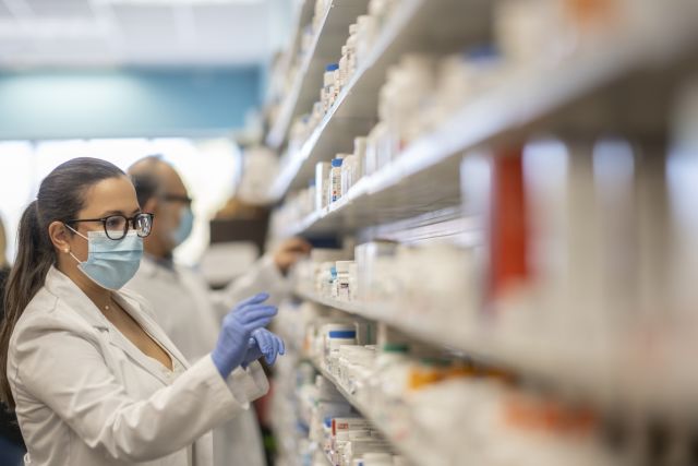 pharmacist perusing drug shelves