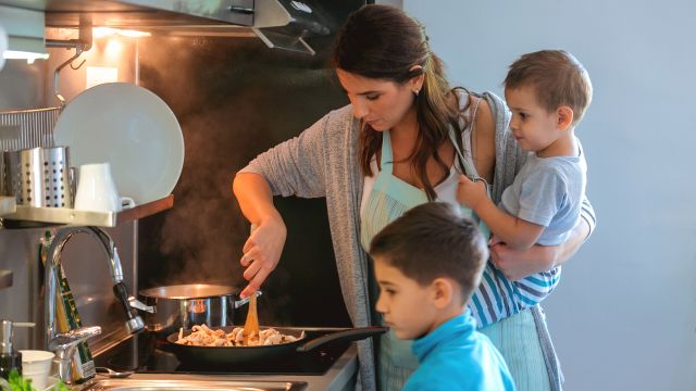 Mother cooking with her two children.