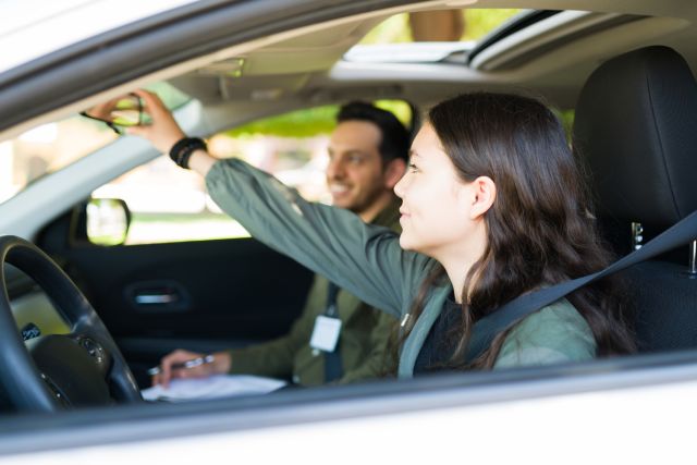 teen girl with adhd concentrating on adjusting mirror during driving test