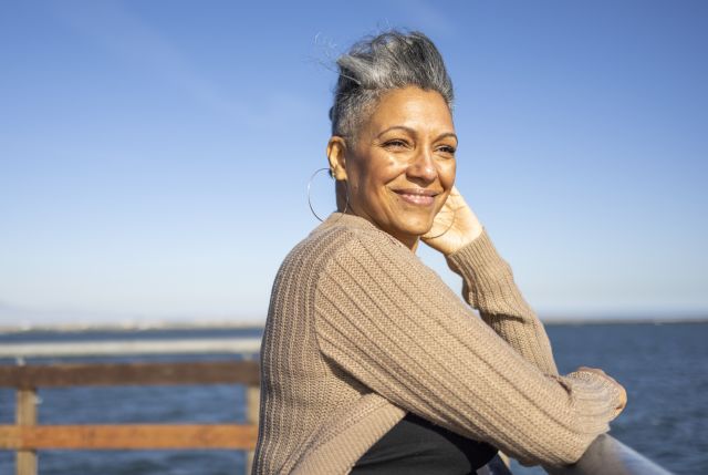Mature black woman with arthritis relaxing at the pier