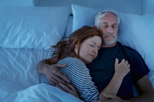 happy sleeping middle-aged couple in bed