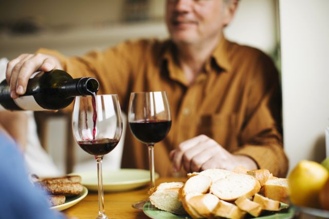 Mature man pouring a glass of red wine