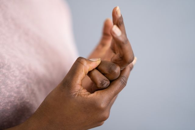 Closeup of a woman's hands while she cracks her knuckles