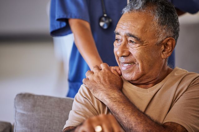 an older Latino man receives comfort from a healthcare provider