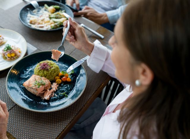 woman eating salmon dinner