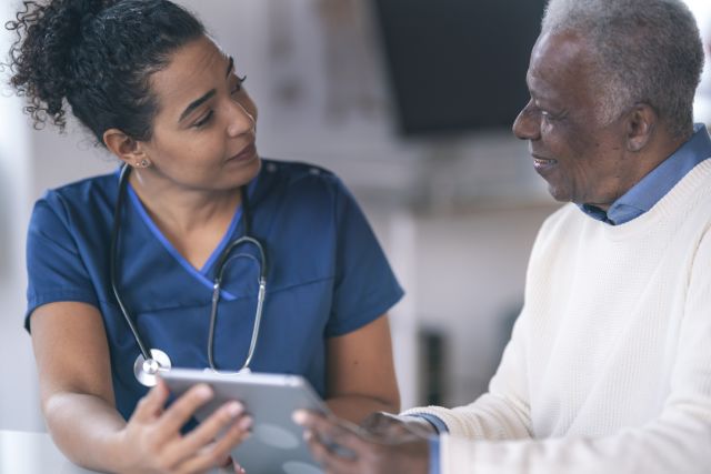 Black older adult speaking with healthcare provider about test results and medical history