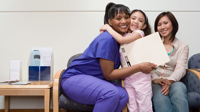 A nurse helping a young girl feel happy and safe before surgery.