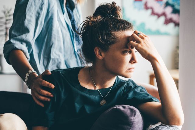 A caregiver for a woman with depression comforts her loved one.