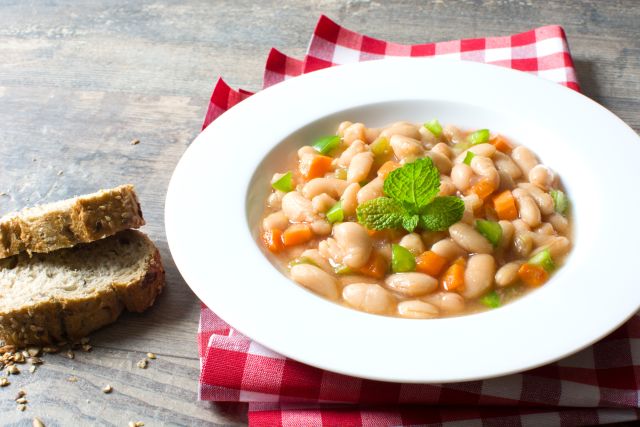 Bowl of beans with vegetables and whole grain bread