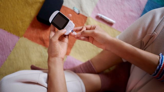 A teenager checks her blood sugar using a blood glucose meter. Blood glucose abnormalities begin to appear in the second stage of type 1 diabetes.