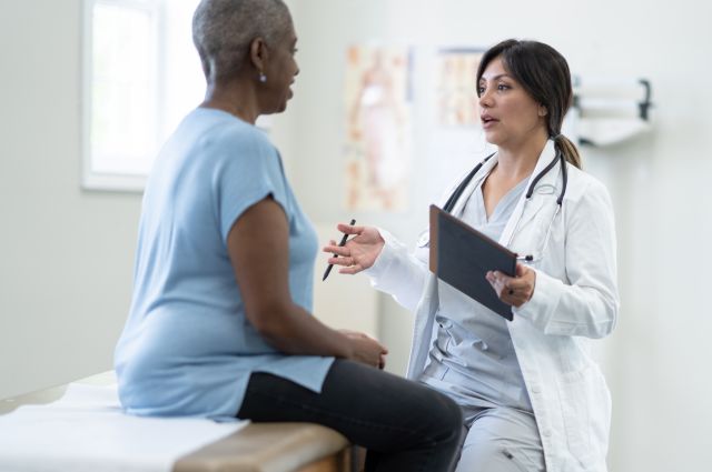 middle-aged Black woman talks to a healthcare provider about her health concerns