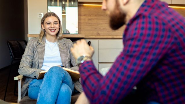 A young man speaks to his therapist during an appointment. A mental health professional can be a valuable addition to a psoriasis healthcare team.