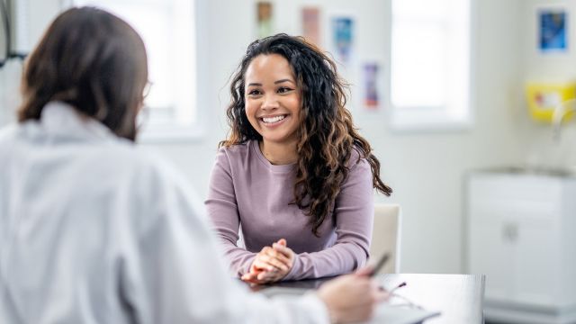 Smiling woman talking to her doctor about cervical cancer risk