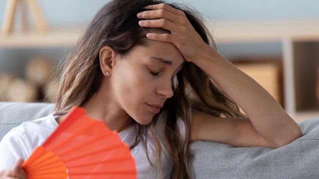 young person cools off using a fan