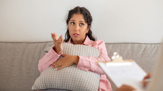 A woman sits on a couch in a therapist office holding a pillow. Treatment for depression often achieves the best results with a combination of medications and psychotherapy.