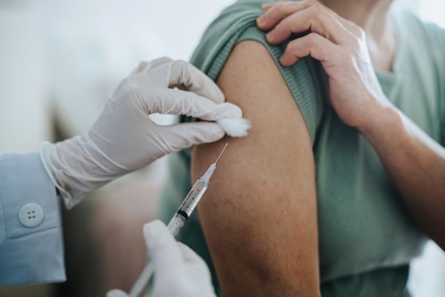 middle-aged person receiving shingles shot in arm