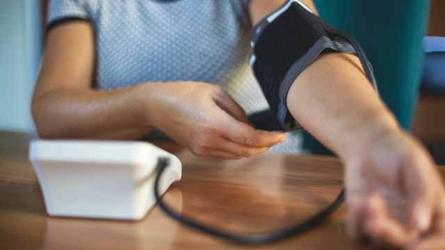 A woman checks her blood pressure at home. Treatment for IgAN often includes medications to control high blood pressure.