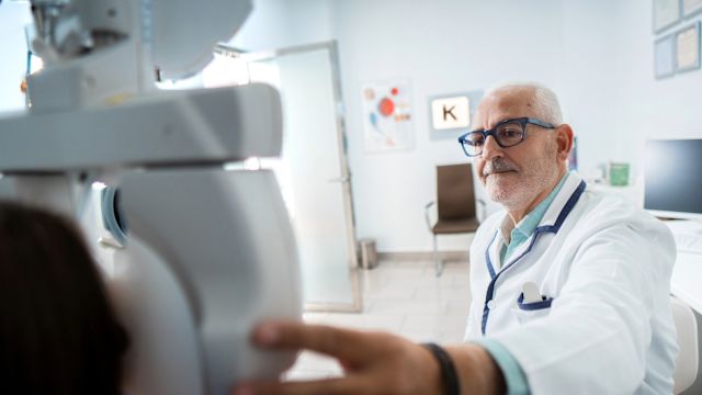 An optometrist tests a patient's vision during an appointment. In many cases an optometrist will be the first healthcare provider a person talks to about signs and symptoms of AMD.