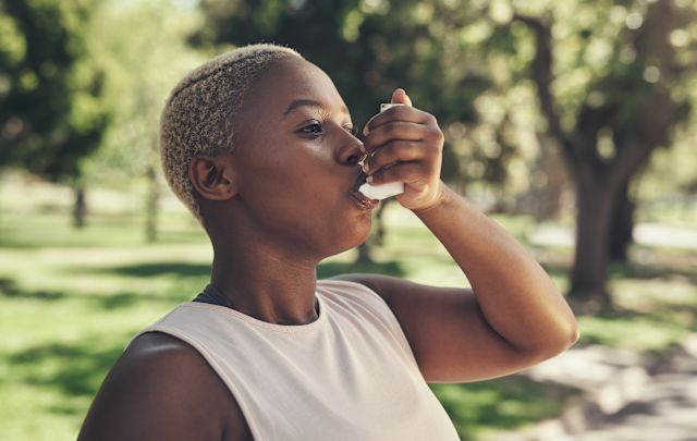 woman using inhaler outdoors