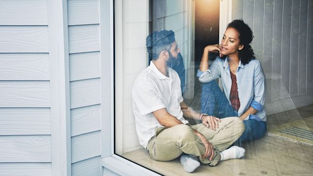 Couple sitting on the floor of their home having a discussion