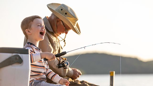 Old man fishing with his grandson