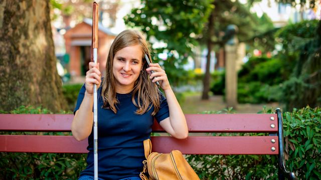 A young woman who has experienced vision loss enjoys a day outside at a park. Vision rehabilitation can help a person living with vision loss maintain independence and quality of life.