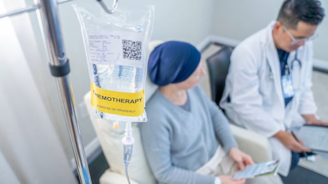 A woman talks to her oncologist while receiving a chemotherapy infusion as part of treatment for metastatic pancreatic cancer.