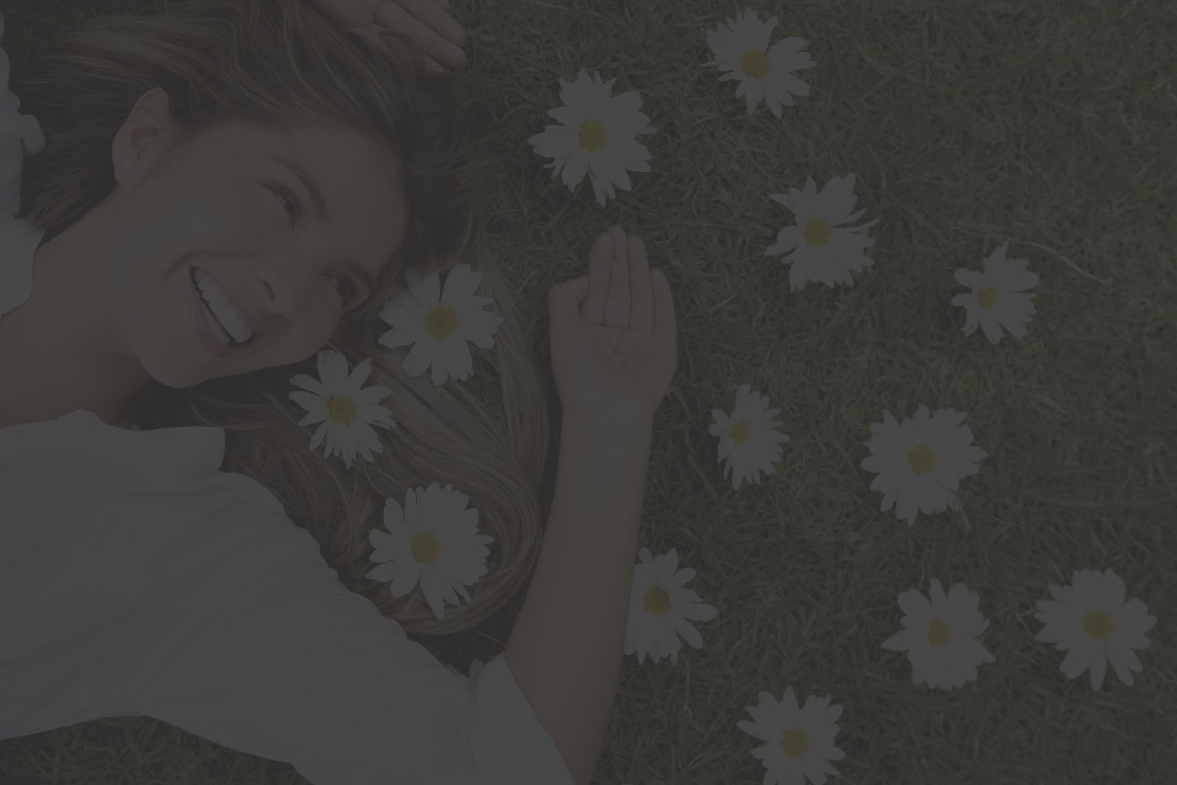 woman laying in the grass with daisy flowers in her hair