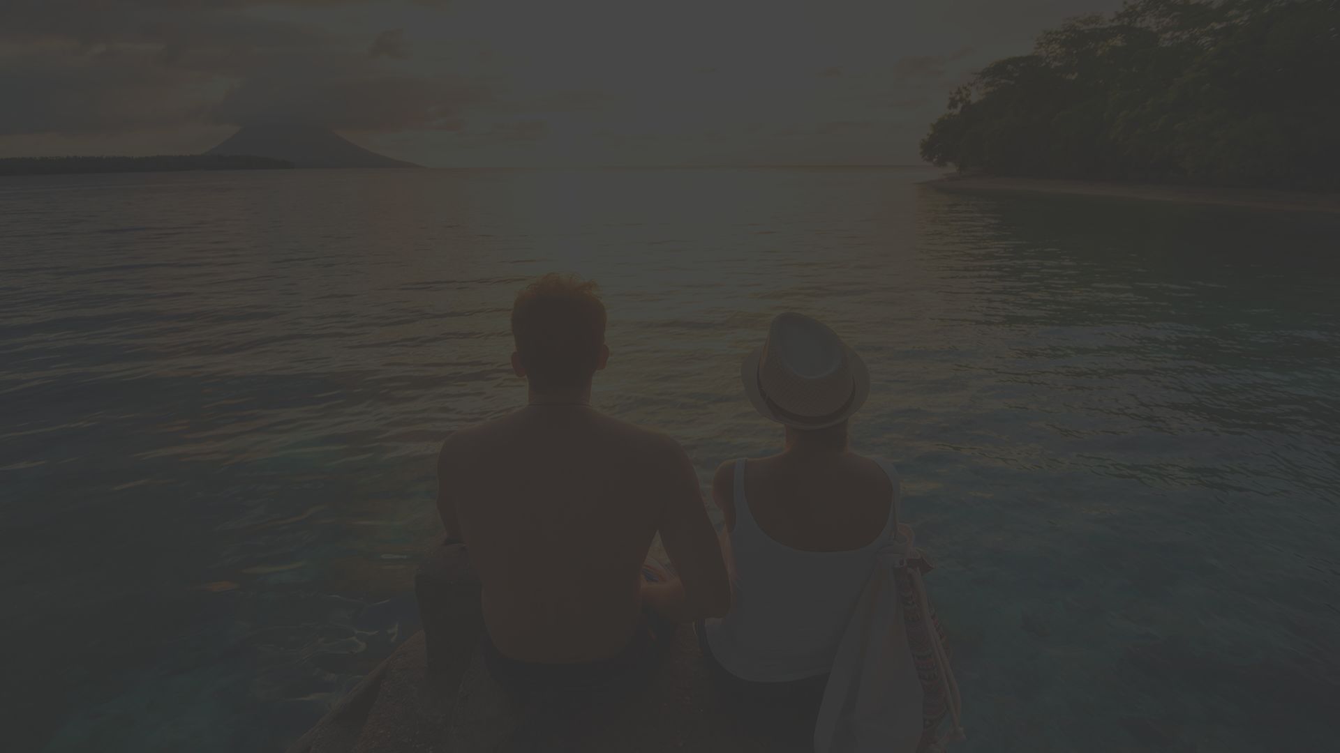 couple sits on beach.