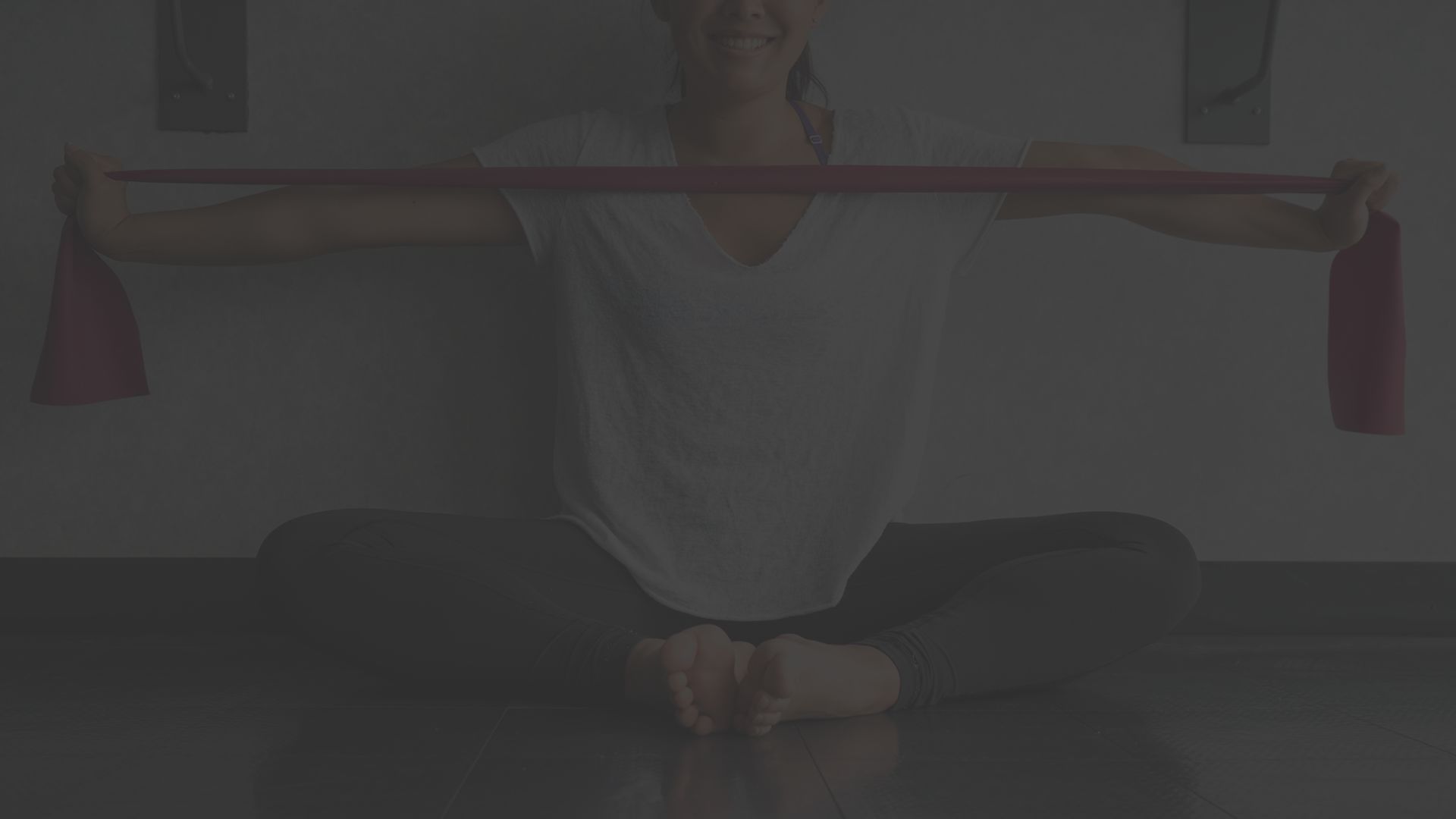 Young woman stretching with resistance bands on the floor.