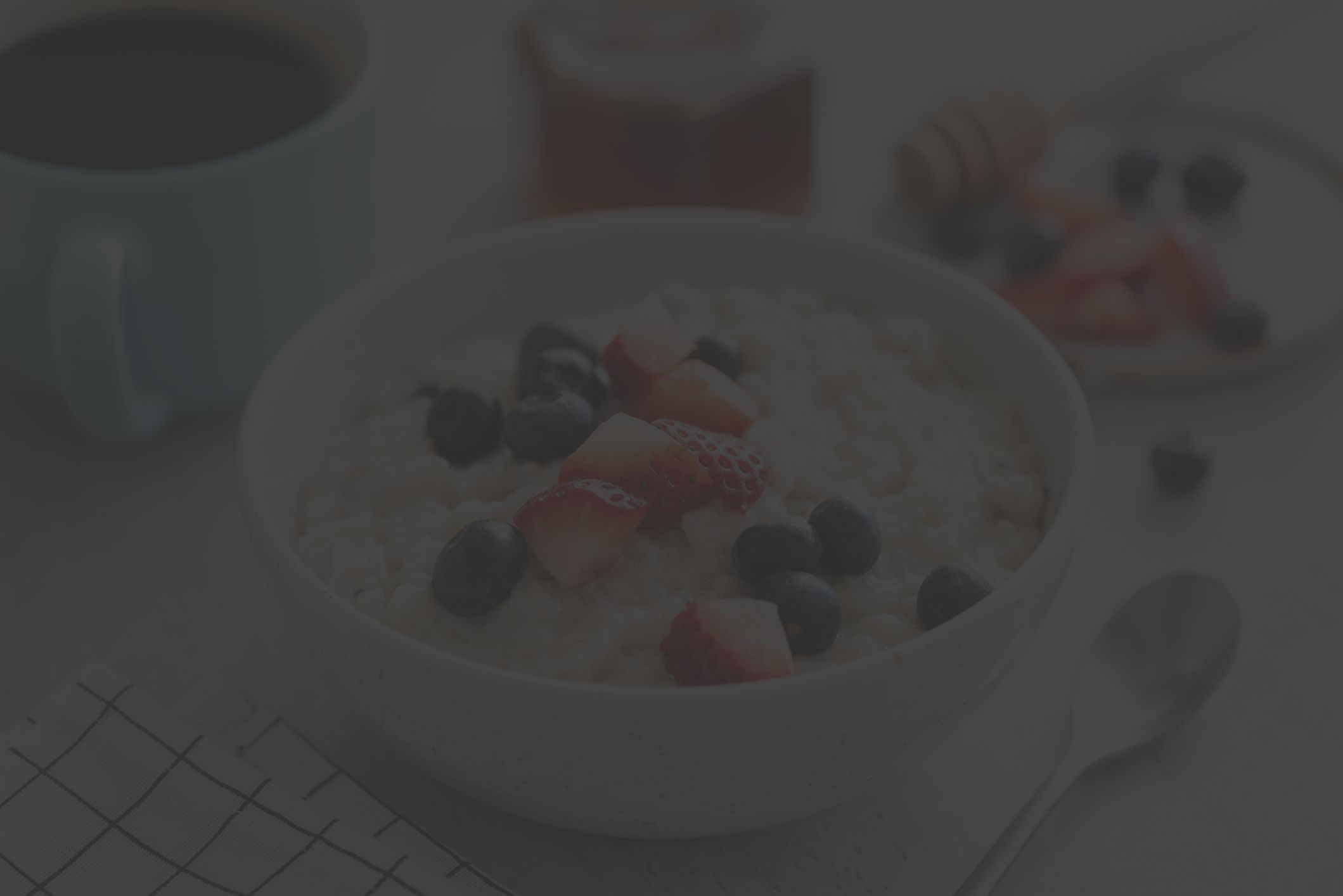 Oatmeal porridge with berries, honey and cup of coffee