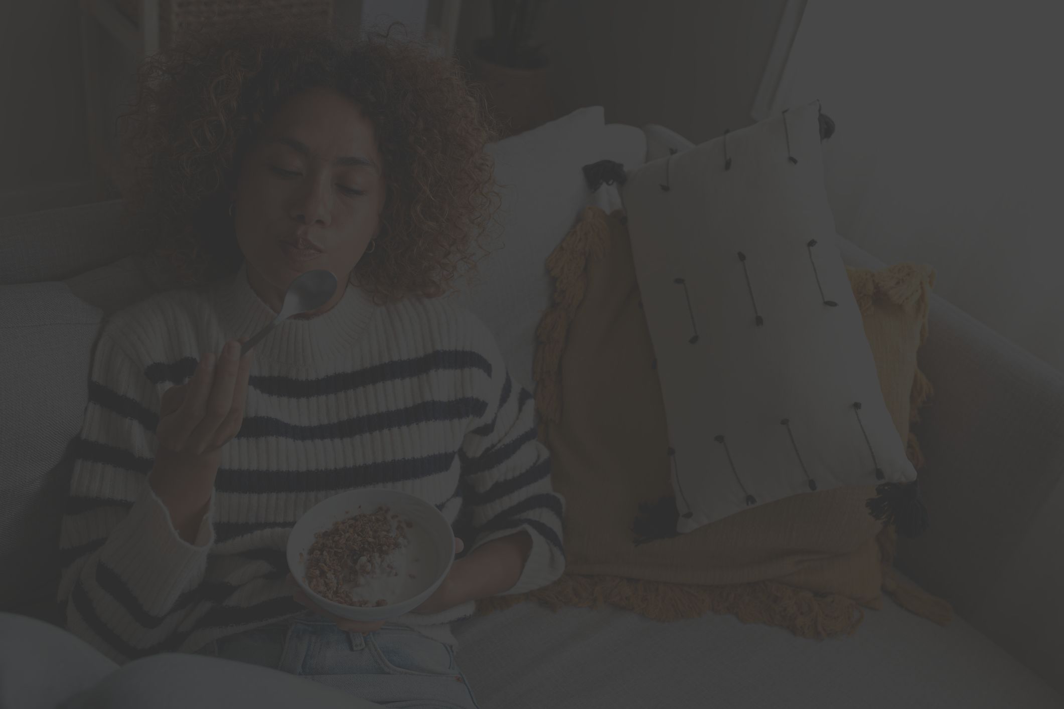 woman eats bowl of nuts, berries, and flaxseed