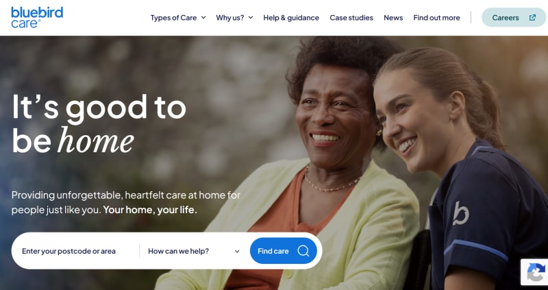 An older woman smiling next to a smiling caregiver in uniform, with the text It is good to be home.